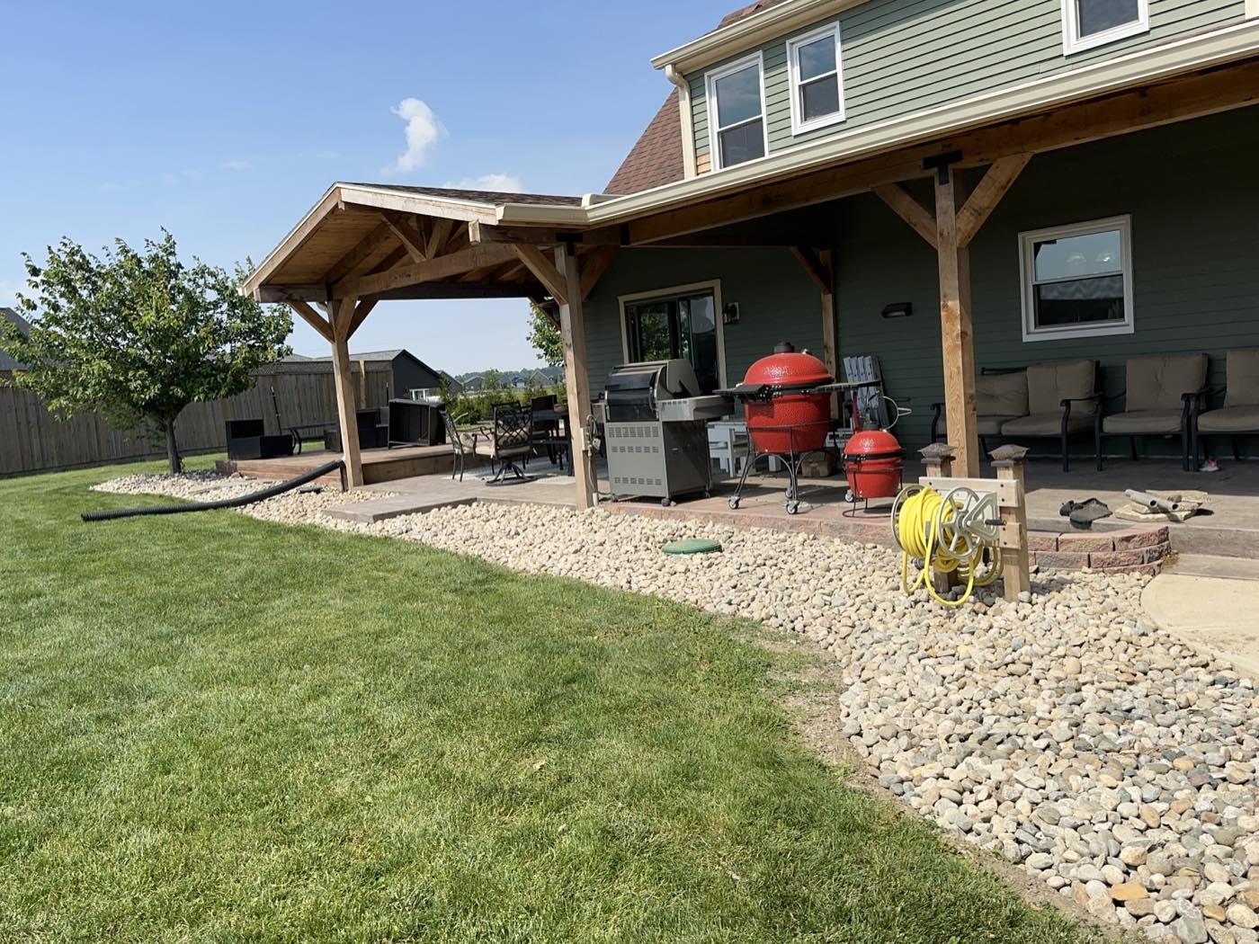 Same patio edge finished with a clean river rock bed